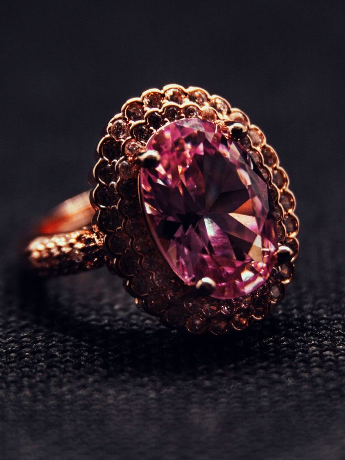 Close-up of a luxurious pink gemstone ring set in intricate gold detailing.